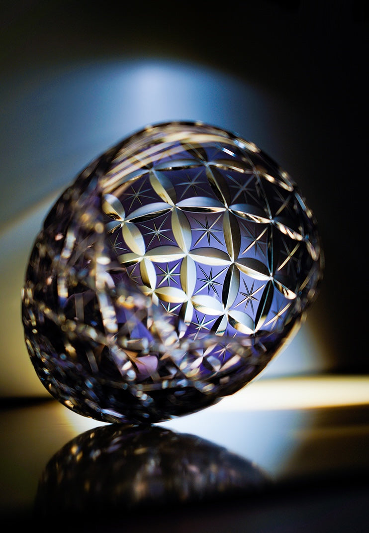 Rin Essense whiskey glass ornate cut crystal tumbler with geometric star pattern tilted on reflective surface