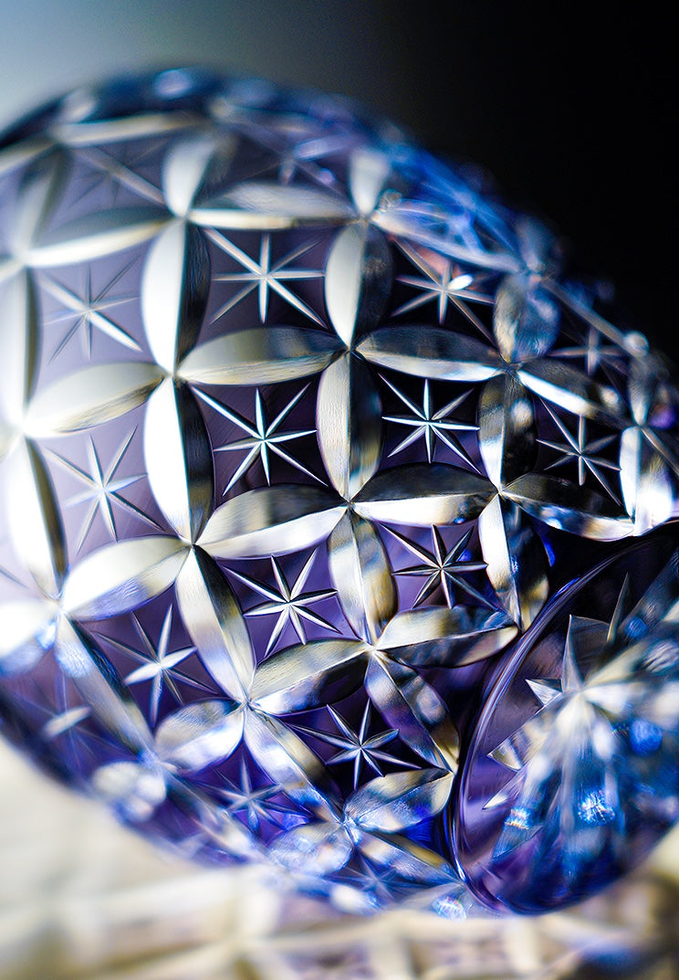 Rin Essense blue cut crystal whiskey glass with intricate star and diamond pattern close up