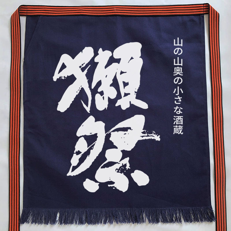 Custom Japanese apron with pattern featuring bold white kanji on navy blue fabric and striped straps