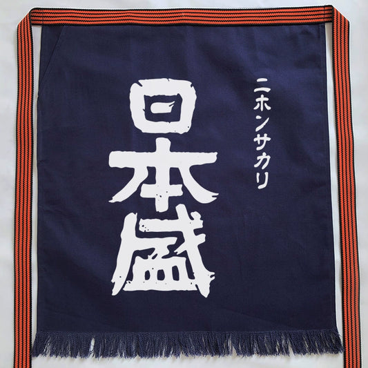 Rin Essense custom Japanese apron with pattern in navy blue featuring white Japanese characters and orange striped straps