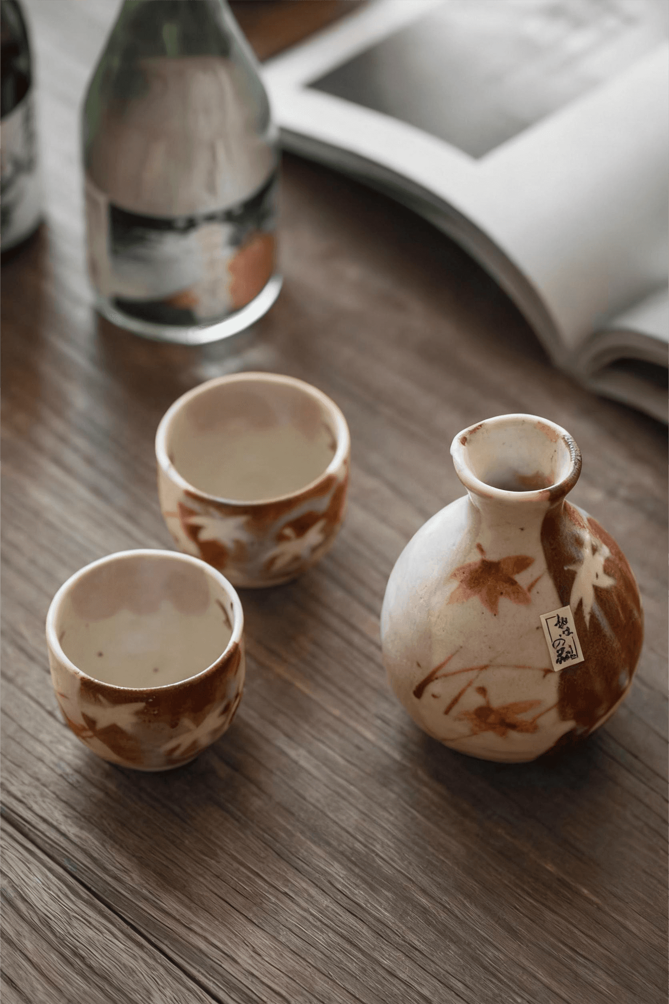 Rin Essense ceramic sake cup set with autumn leaf design on wooden table