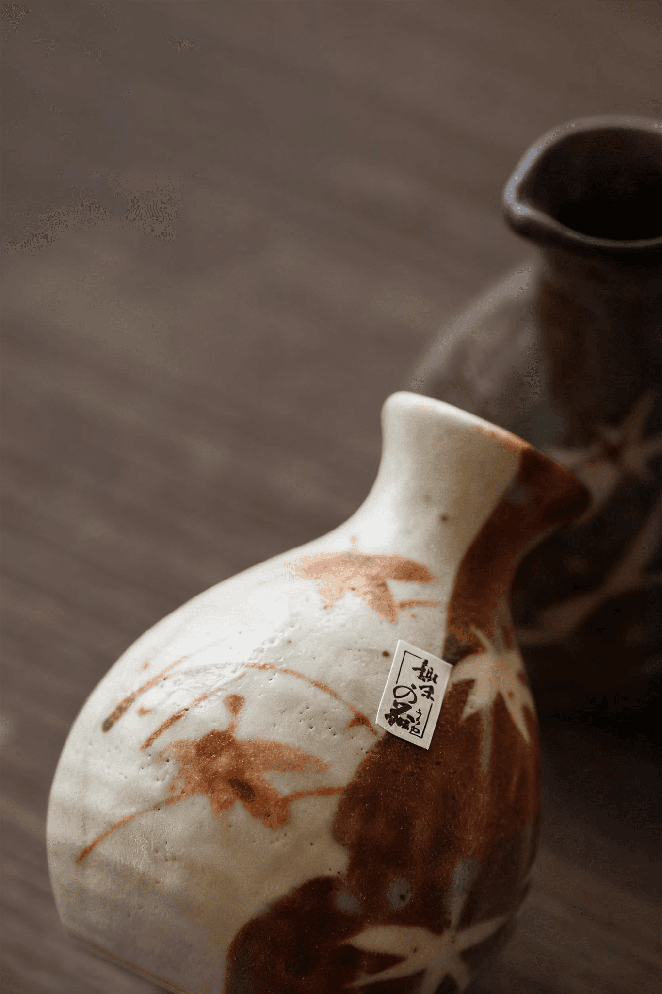 Rin Essense ceramic sake cup with brown and white leaf design on wooden surface
