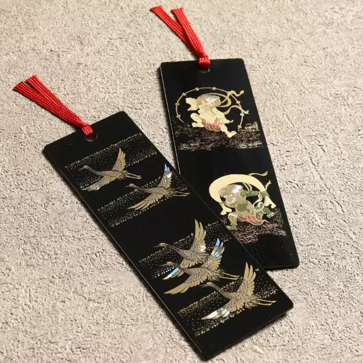 Pair of black handcrafted lacquerware bookmarks with red tassels and gold crane and moon inlay