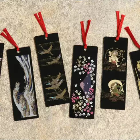 Set of black handcrafted lacquerware bookmarks with red tassels featuring cranes cherry blossoms and traditional Japanese motifs