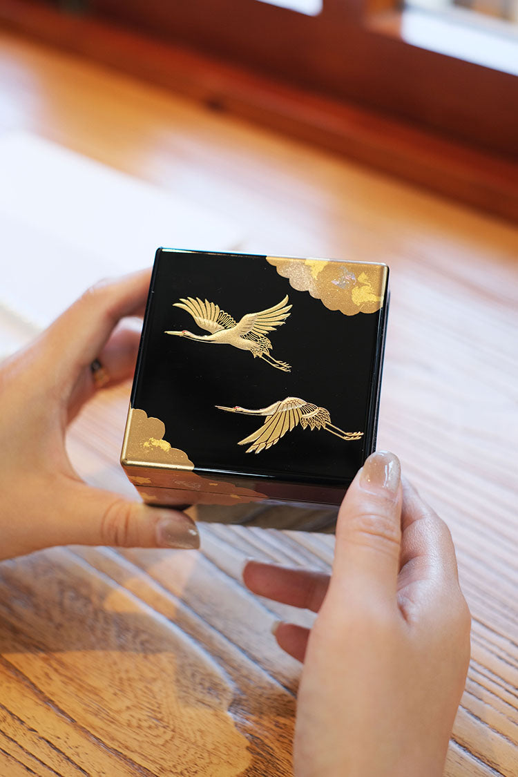 Rin Essense Japanese lacquerware jewelry box black square with gold cranes held in hands on wood