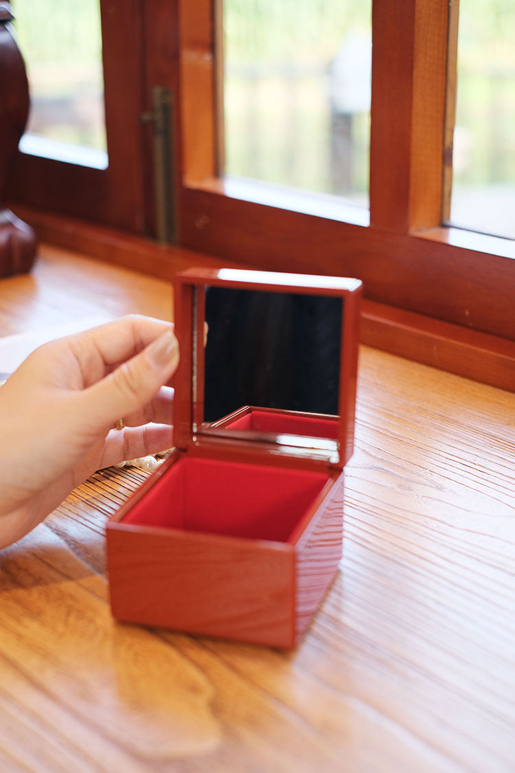 Rin Essense Japanese lacquerware jewelry box open with mirror and red velvet interior on wood table