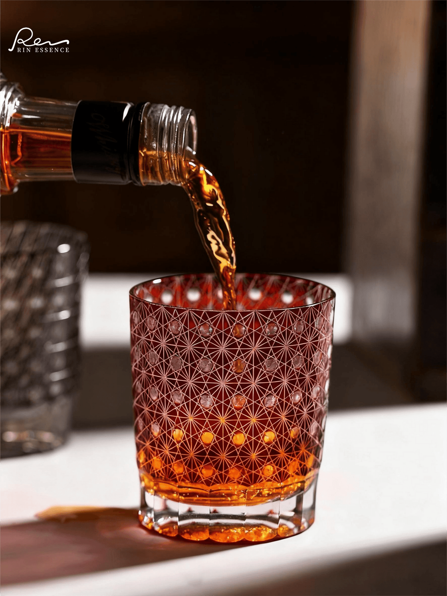 Rin Essense Edo Kiriko style drinkware red sake cup with intricate cut glass pattern and amber liquid pouring in