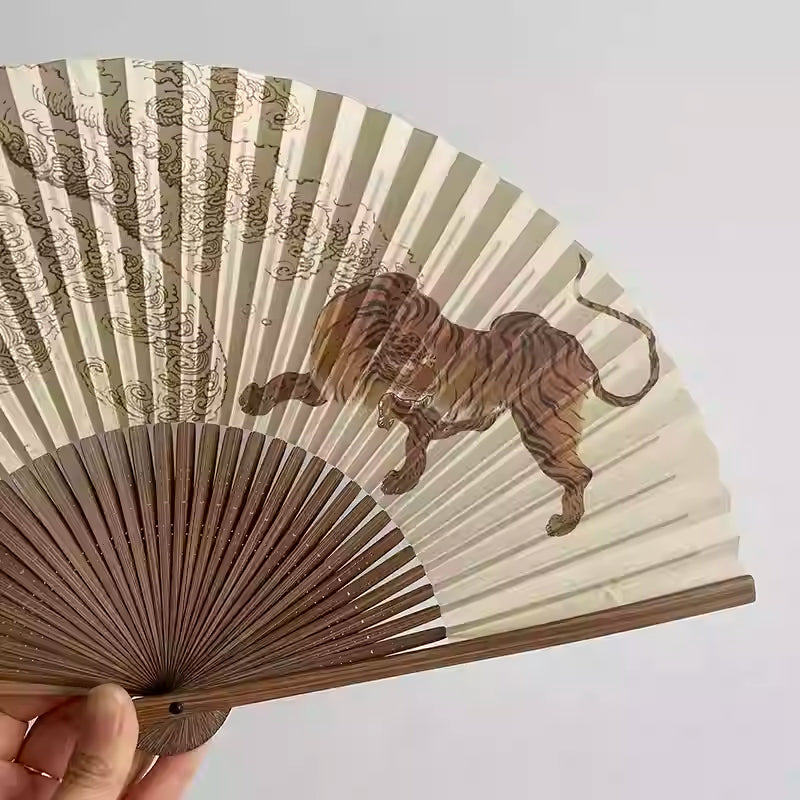 Rin Essense hand fan with wooden ribs featuring a tiger and cloud design on beige background