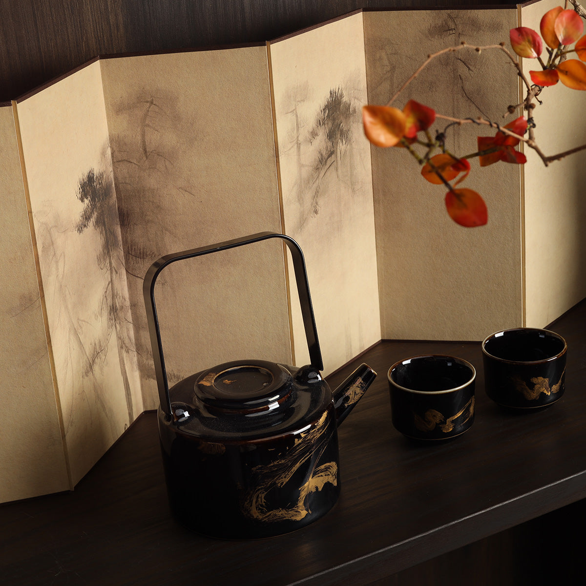 Rin Essense black lacquer teapot and two cups with gold design before a washi shoji folding screen