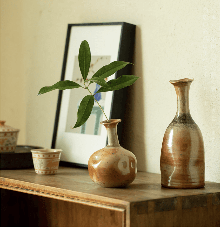 Rin Essense mini flower vase Japanese decor with green leaf on wooden surface beside pottery and framed art