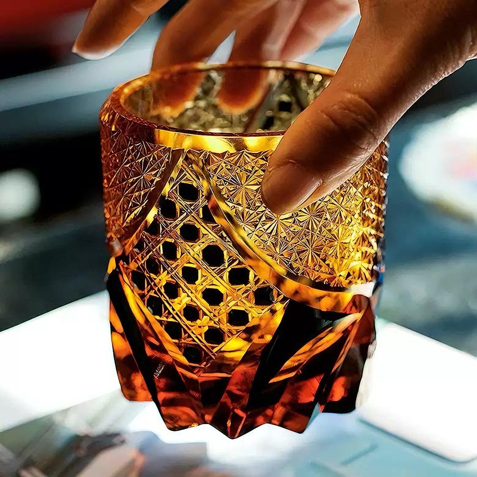 Rin Essense Satsuma Kiriko whiskey glass amber cut crystal tumbler held by hand showing intricate geometric patterns