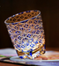 Rin Essense Edo Kiriko whisky glass in blue cut crystal with intricate star pattern lit by warm light