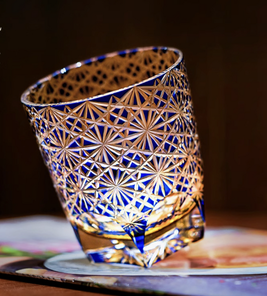 Rin Essense Edo Kiriko whisky glass in blue cut crystal with intricate star pattern lit by warm light