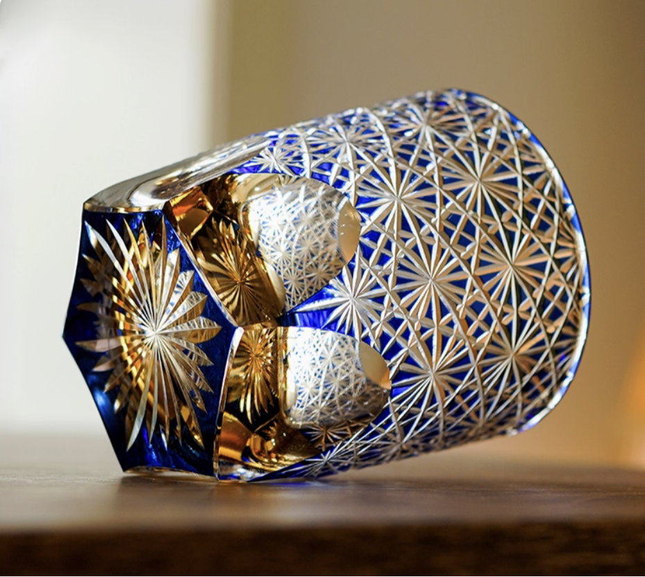 Edo Kiriko whisky glass hand cut blue crystal with intricate star pattern resting on wood