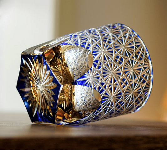 Edo Kiriko whisky glass hand cut blue crystal with intricate star pattern resting on wood