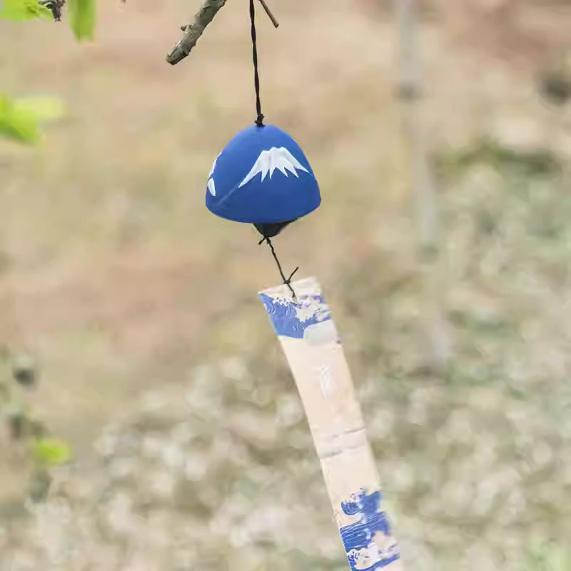 Rin Essense blue Mount Fuji ceramic wind chime with decorative paper strip hanging from a tree