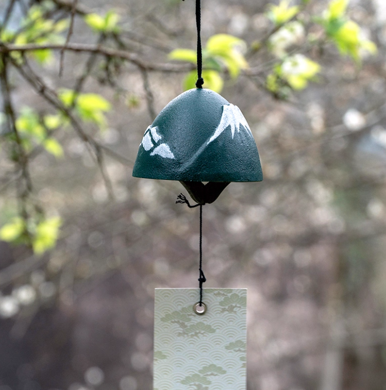 Rin Essense green Japanese wind chime with white mountain design and decorative paper strip hanging outdoors