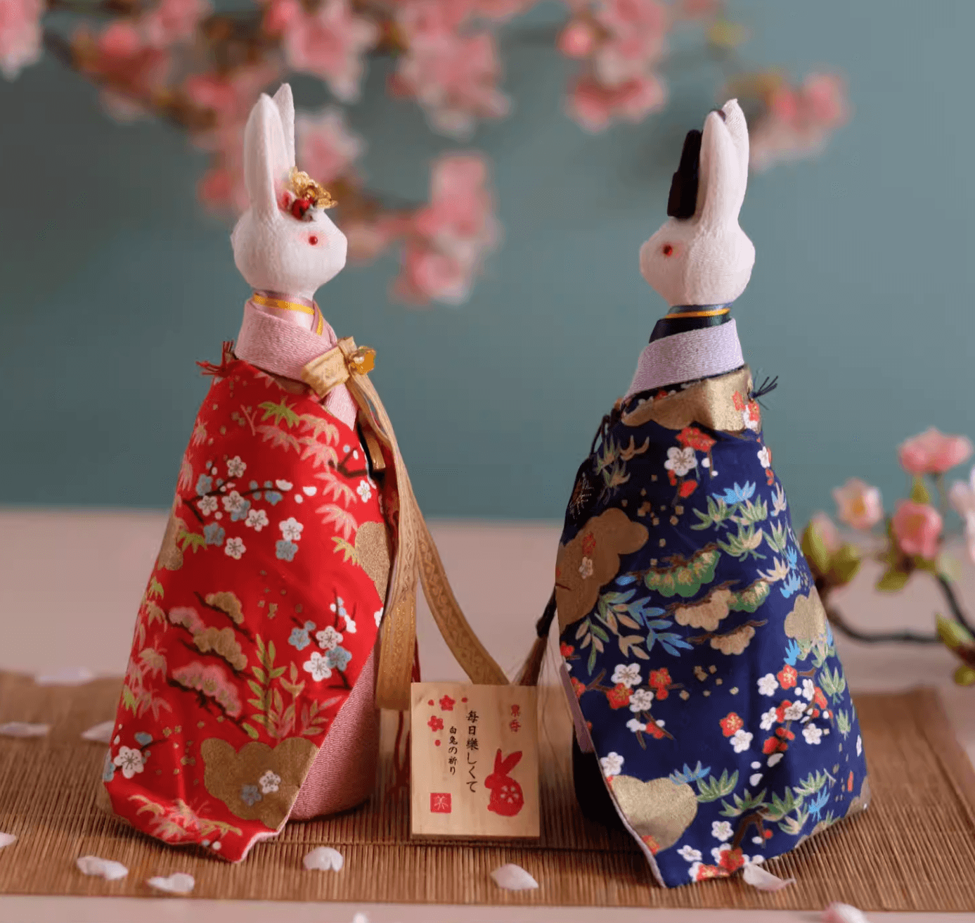 Rin Essense decorative rabbit dolls dressed in traditional red and blue floral kimonos with a wooden sign