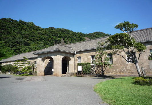 Historic stone building surrounded by greenery and blue sky representing traditional Japanese culture and Satsuma Kiriko glass and Japanese whisky pairing