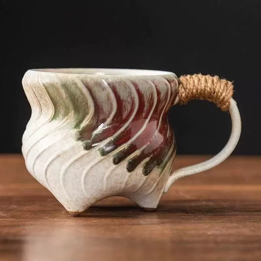 Rin Essense handmade stoneware coffee mug with wavy textured glaze in green and red and jute wrapped handle