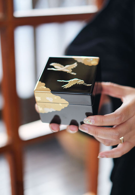 Rin Essense Japanese lacquerware jewelry box black with gold cranes and cloud design held in hands