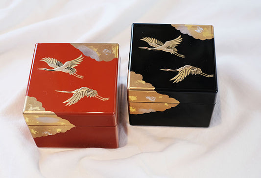 Pair of Rin Essense Japanese lacquerware jewelry box pieces in red and black with gold crane and cloud motif