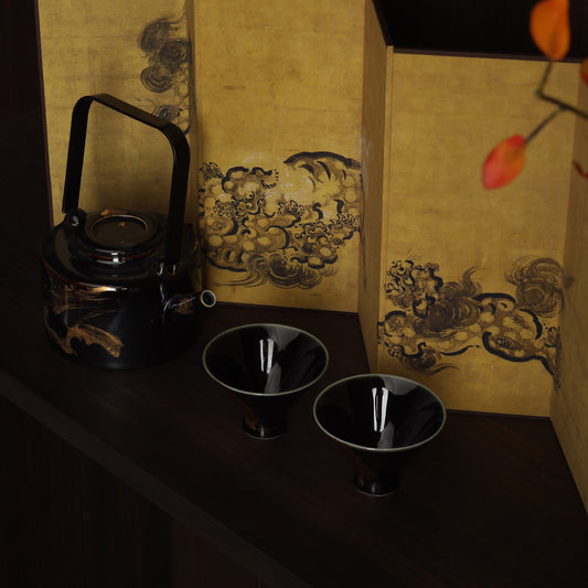 Washi shoji folding screen with gold ink cloud panels beside black lacquer teapot and two cups
