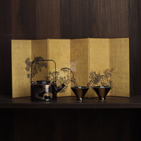 Washi shoji folding screen gold leaf panel behind Rin Essense black lacquer teapot and two matching tea cups