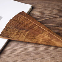 Close-up of golden nanmu wood folding fan with fine grain texture on wooden surface