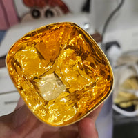 Close-up of hand-shaped gilded Japanese cup showing shiny gold interior held in hand