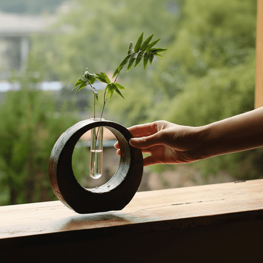Rin Essense modern japanese vase with circular wooden frame and glass tube holding green leaves