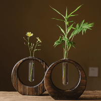 Rin Essense japanese vase set with circular wooden frame and glass tube holding green leaves and yellow flowers
