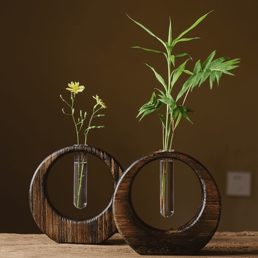 Rin Essense japanese vase set with circular wooden frame and glass tube holding green leaves and yellow flowers