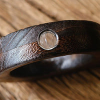 Rin Essense japanese vase with dark wood texture and circular glass detail on wooden surface