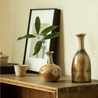 Rin Essense mini flower vase Japanese decor with green leaf on wooden surface beside pottery and framed art