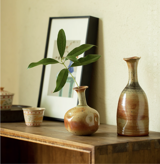 Rin Essense mini flower vase Japanese decor with green leaf on wooden surface beside pottery and framed art