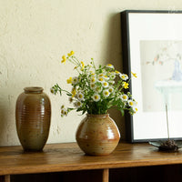 Mini flower vase Japanese decor with fresh white and yellow daisies on wooden shelf