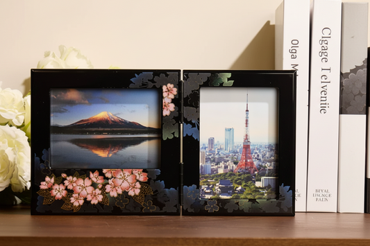 Rin Essense decorative black photo frame with floral design holding two landscape photos on a wooden shelf