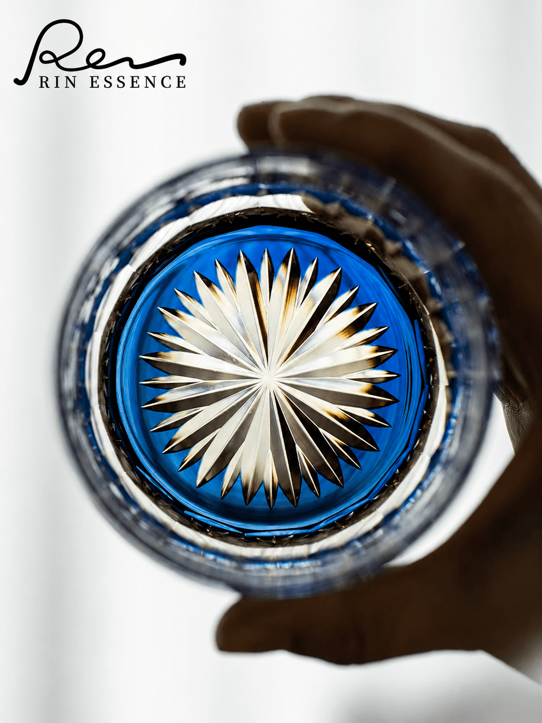 RIN ESSENCE glass whiskey with intricate starburst design viewed from top held in hand