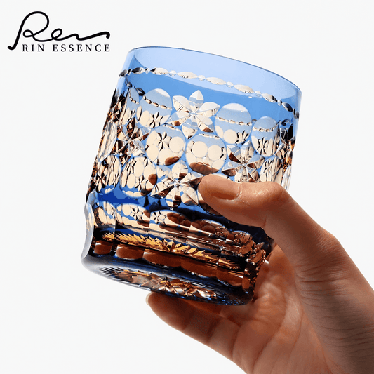 RIN ESSENCE glass whiskey with intricate cut design held in hand with amber liquid