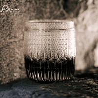 Rin Essense whiskey glass with intricate cut pattern and dark liquid inside showcasing whiskey with glass