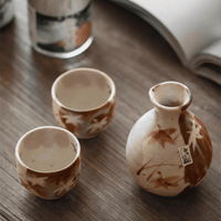 Rin Essense ceramic sake cup set with autumn leaf design on wooden table