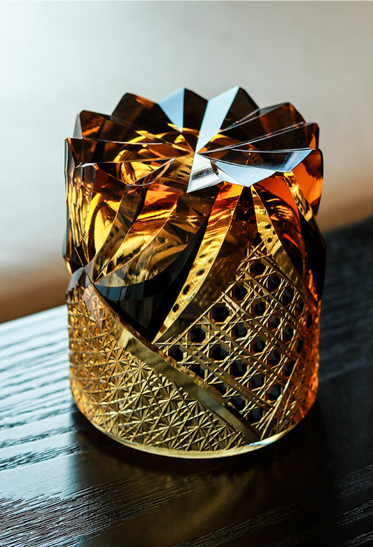 Satsuma Kiriko whiskey glass by Rin Essense amber cut crystal tumbler with intricate lattice and star cuts on dark wood