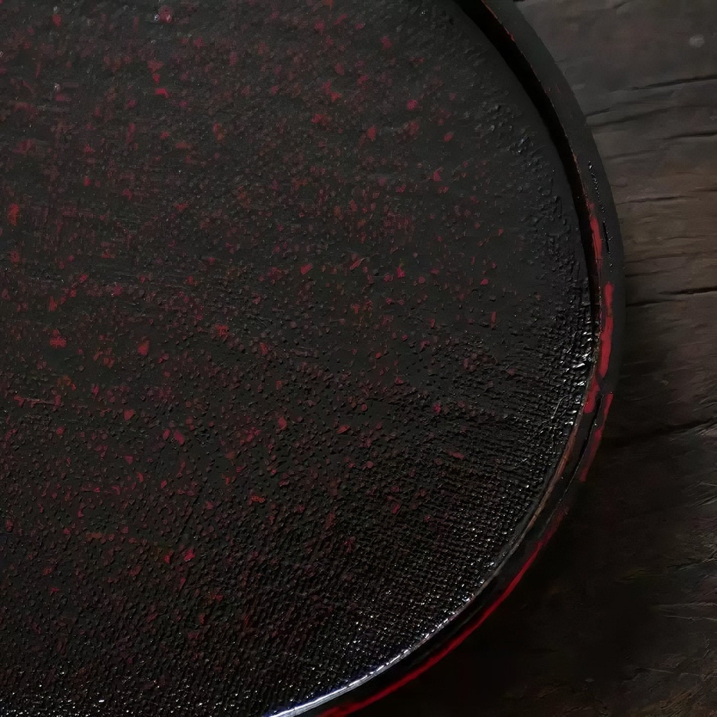 Rin Essense round textured black and red tea tray on wooden surface