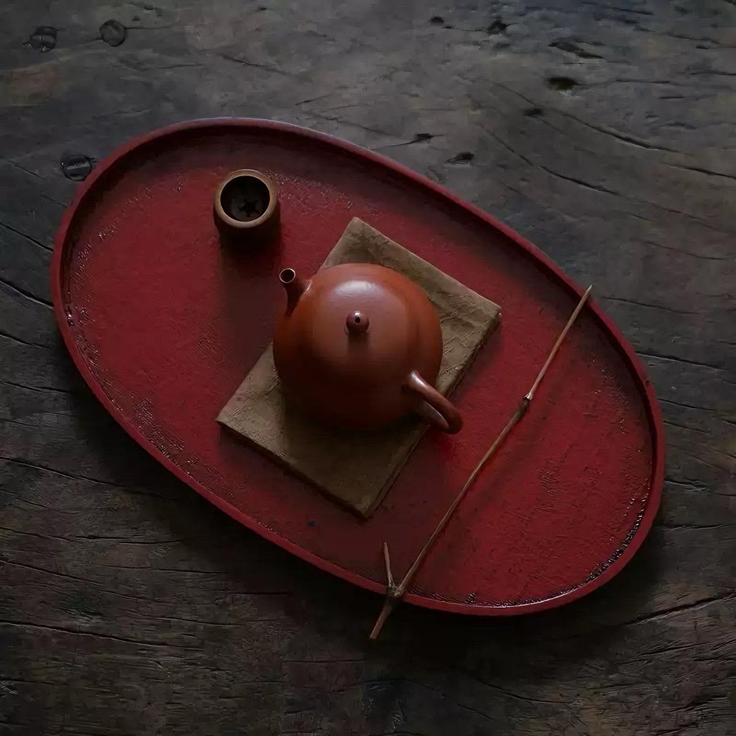 Rin Essense red oval tea tray with traditional brown teapot and tea accessories on wooden surface