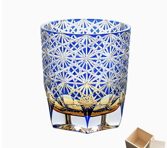 Rin Essense Edo Kiriko whisky glass blue cut crystal tumbler with intricate star pattern holding amber whisky