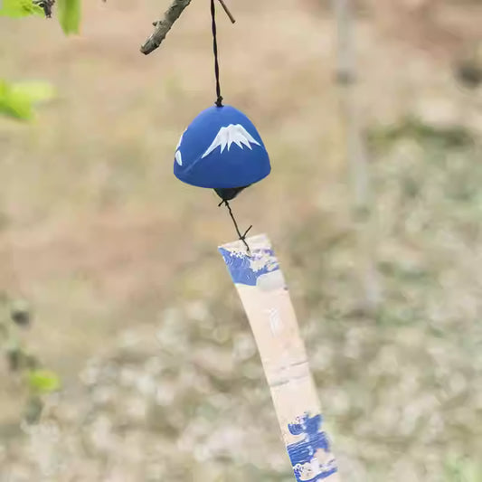 Rin Essense blue Mount Fuji ceramic wind chime with decorative paper strip hanging from a tree