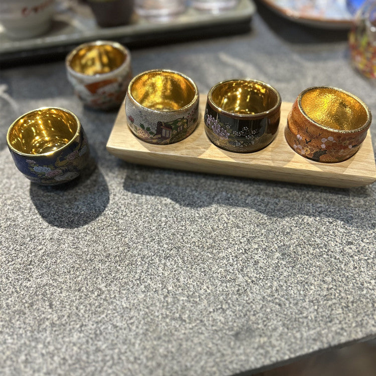Rin Essense traditional Japanese ceramic drinkware sake cups with gold interior and decorative exteriors on a wooden tray
