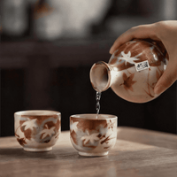 Rin Essense sake cup set with autumn leaf design and hand pouring sake into cup