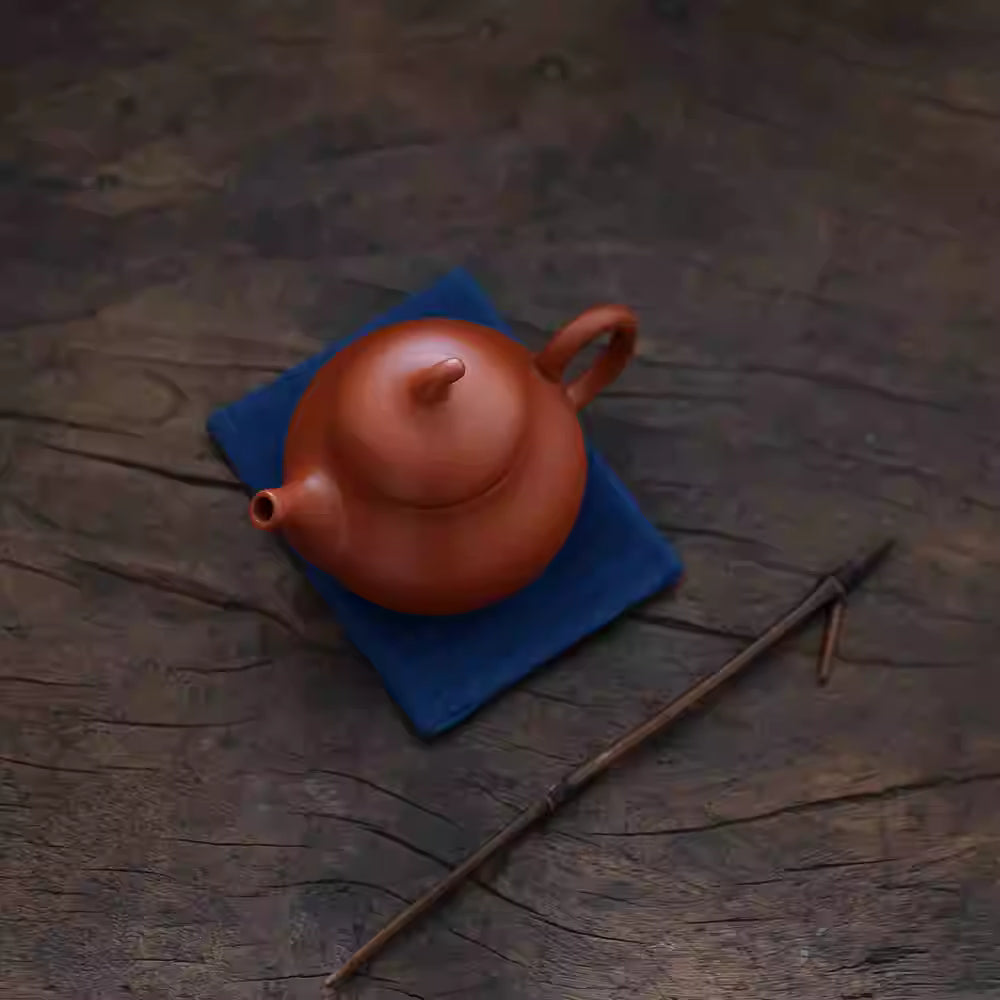 Japanese Indigo Tea Cloth – Hand-Dyed Cotton Linen placed under a red clay teapot on wooden surface
